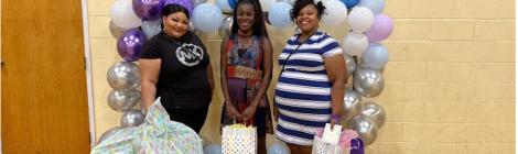 Expectant mothers display gifts they received from the Community Baby Shower. 