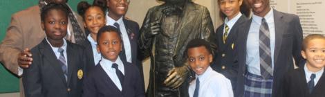 George E. Thornton, Sr., principal of the Dupont Park Adventist School, and eight students (left of the statue) Imani Yates, Simone Scott, Ayanna McInnis, Christopher Henderson, (right of the statue) Chase McClure, Jaffe Watkins, Dorian Donovan and Lawrence Talbert stand next to a Frederick Douglass statue.