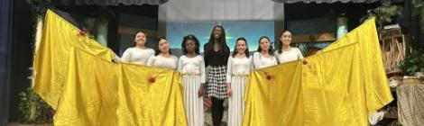 Naomie Charles (center) joins Lake Nelson Adventist Academy students at a holiday program.