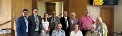 Walter Cardenas (left), assistant to the conference president, and Roger Curtis (second to left), pastor of the Parsons church, join members to rededicate the church.