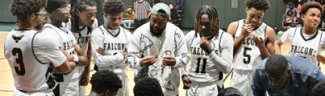 The boys’ varsity basketball team huddle during a timeout.