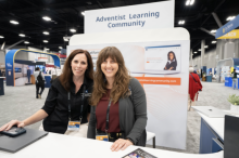 Paola Franco-Oudri, associate director of Adventist Learning Center and Heather More, project manager for Adventist Learning Community, greet people at the NAD portion of GC Session exhibit hall. Photo by Katie Fellows / Lake Union Herald