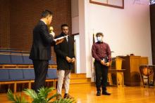 Pastor Sanghae Kim reads the baptismal vows to candidates Kyle Williams and Joseph Berry.