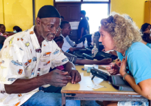 New Hope member Monika Korff (right) provides a medical screening to a Grenadian.