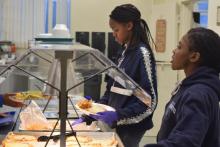 Junior Sh’Dai Forrester and freshman Miya Fields serve food in the cafeteria.