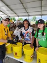 Sung Kwon, North American Division ACS executive director, seals buckets after Pathfinders will them with cleaning supplies at the 2019 Chosen International Camporee in Oshkosh, Wisconsin. 