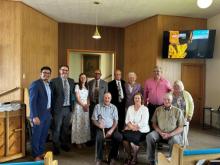 Walter Cardenas (left), assistant to the conference president, and Roger Curtis (second to left), pastor of the Parsons church, join members to rededicate the church.