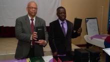 Giles McGill, president of the Abokin Evangelistic group in Africa, and Sampson Twumasi, pastor of the Columbus Ghanaian church, distribute Bibles to Sunday-keeping pastors during a graduation ceremony.