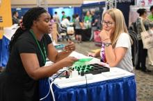 Potomac Conference Teacher Laurie Hartman Kelly talks with an exhibitor at the NAD Educators' Convention. | Photo by Columbia Union Visitor