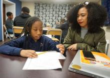 Amy Thomas, a student at Temple University, tutors third-grader Jodi Glenn as part of the REACH Success after-school program.