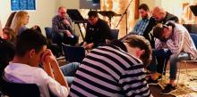 Edward Marton, Ohio Conference’s Youth Ministries director, leads prayer with high school students and youth pastors during the “ReCharge” event at the Worthington church.