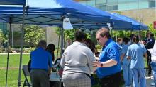 Adventist HealthCare Chaplain Ryan Ryan Comeau prays with an attendee