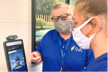 School nurse Trixi Johnson checks senior Natalie Cook’s temperature, a required protocol for daily entrance.