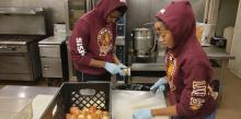 Seniors Lyden Stanislaus-Niles and Taylore Williams help cut onions at Elijah’s Promise Community Kitchen.