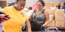 A volunteer distributes clothing at the World Harvest Outreach church in Houston. Photo by Keith Goodman