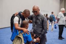  Sibusiso B. Khumalo, director of GC Youth Ministries, prays with a young person at the General Conference Session. Photo by Nicol Belvedere/AME (CC BY 4.0)