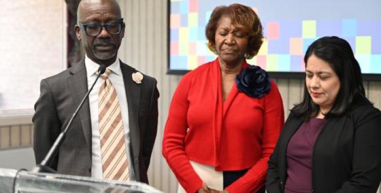 Donovan Ross, VP of Education for the Columbia Union, prays for Cynthia Poole and Ruth Nino, new associate directors for education.