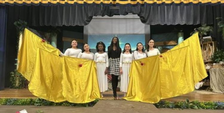 Naomie Charles (center) joins Lake Nelson Adventist Academy students at a holiday program.