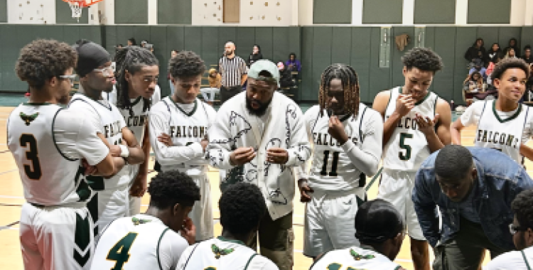 The boys’ varsity basketball team huddle during a timeout.