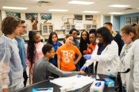 An instructor from Kettering College draws blood  from phlebotomy student Brayden Oehlenschlager, as his classmates look on.