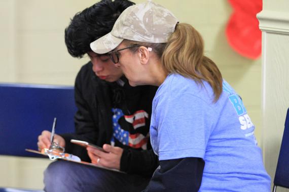 Luci Sloan, a volunteer from Beltsville Adventist Community Center, helps one of the students register for the free eye exam. 