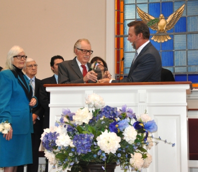 Dave Weigley (right), Columbia Union president, presents former U.S. Congressman Roscoe Bartlett with an engraved award for his 20 years of public service, while his wife, Ellen, looks on.