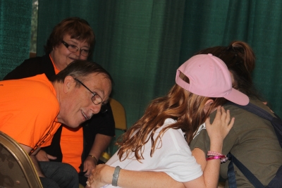 Milton and Margo Chappell, members of Sligo church, comfort a crying little girl at the prayer tent.