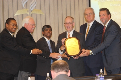 Jacob Prabhakar Chindrupu, MD, presents a thank-you plaque to the Columbia Union’s three officers and the presidents of the union’s two healthcare systems.
