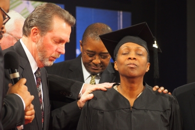 Dave Weigley (left), Columbia Union president, and Seth Bardu, Columbia Union treasurer, lay hands on Brenda Billingy, senior pastor of the Metropolitan church in Hyattsville, Md., during her surprise ordination service. 
