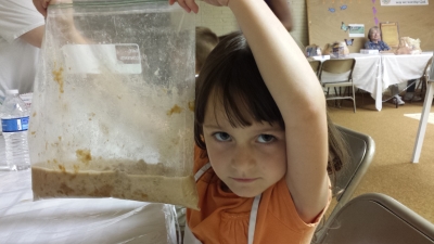 Tisha, 6, holds up a work in progress—whole wheat bread in a bag.