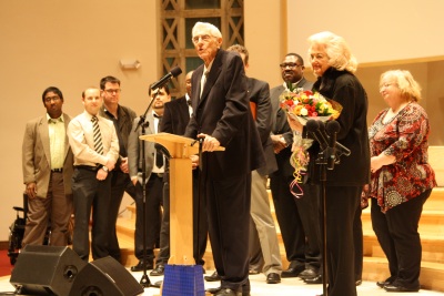 WGTS staff surround Gerry Fuller and his wife, Joy, on stage.